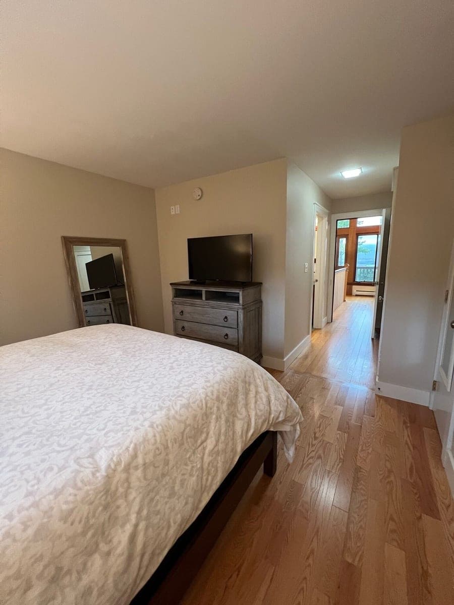VRBO bedroom with television and balcony access