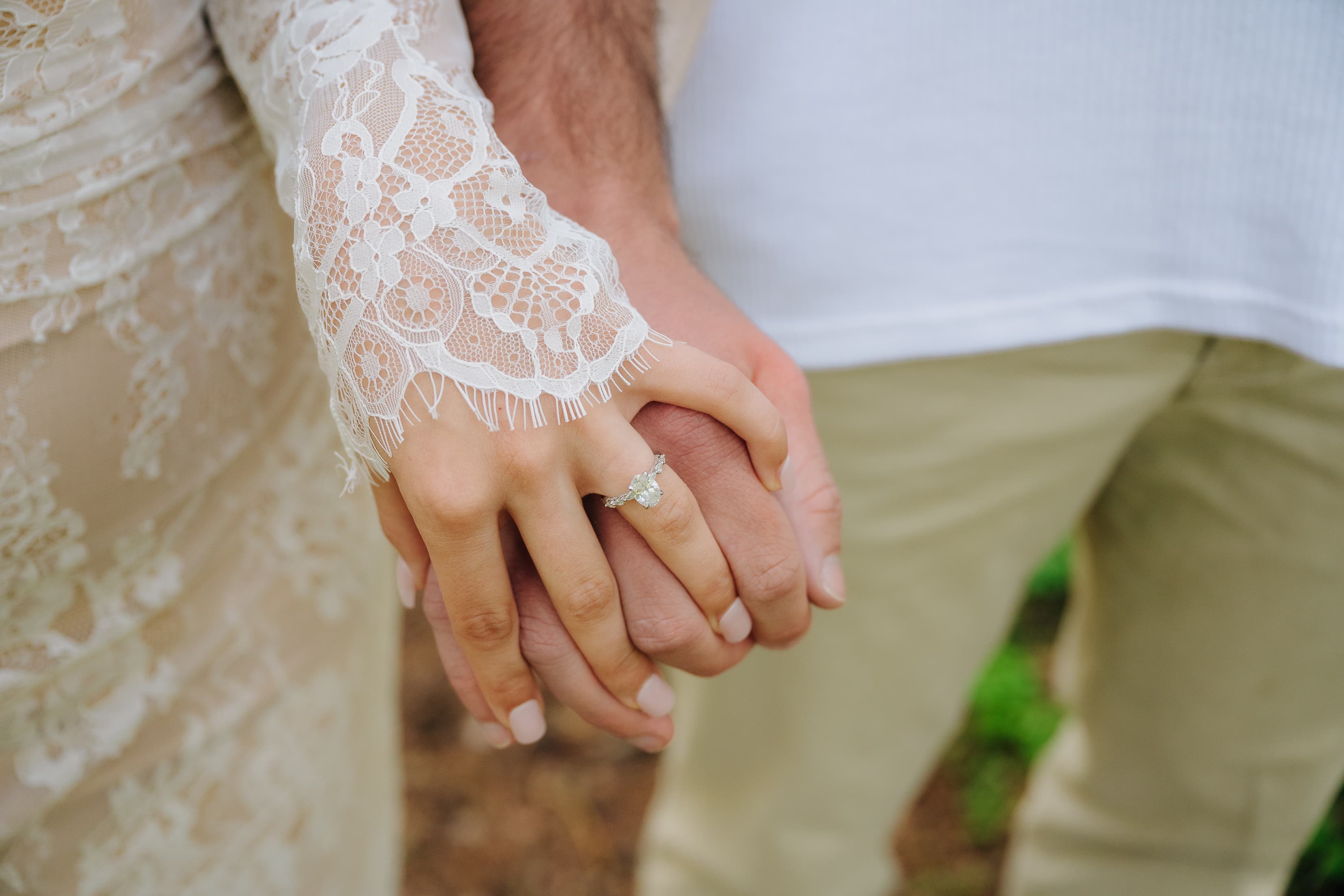 A close-up of JT and Nicole holding hands.