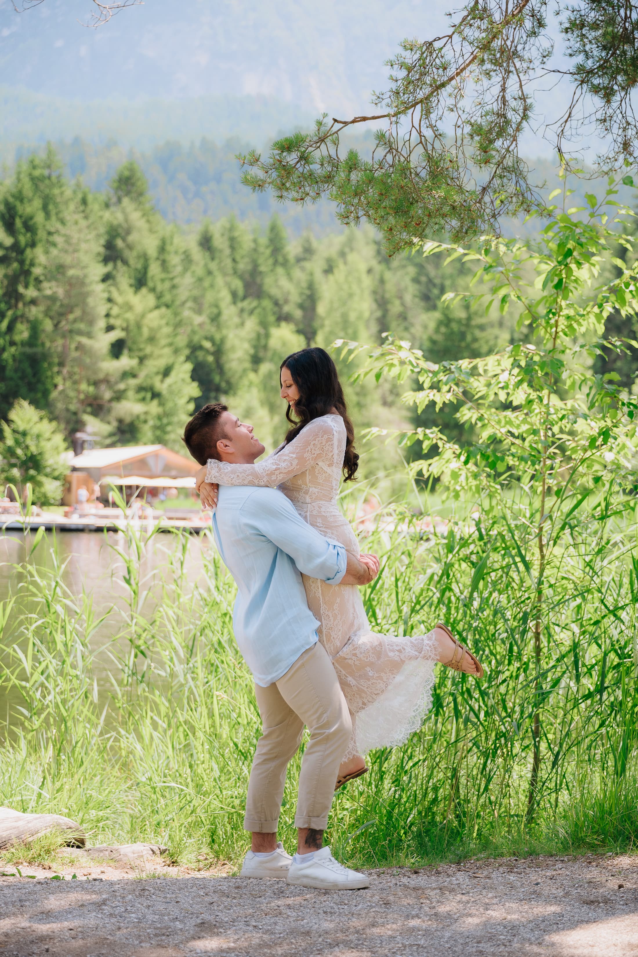 JT lifting Nicole in a green mountain setting.