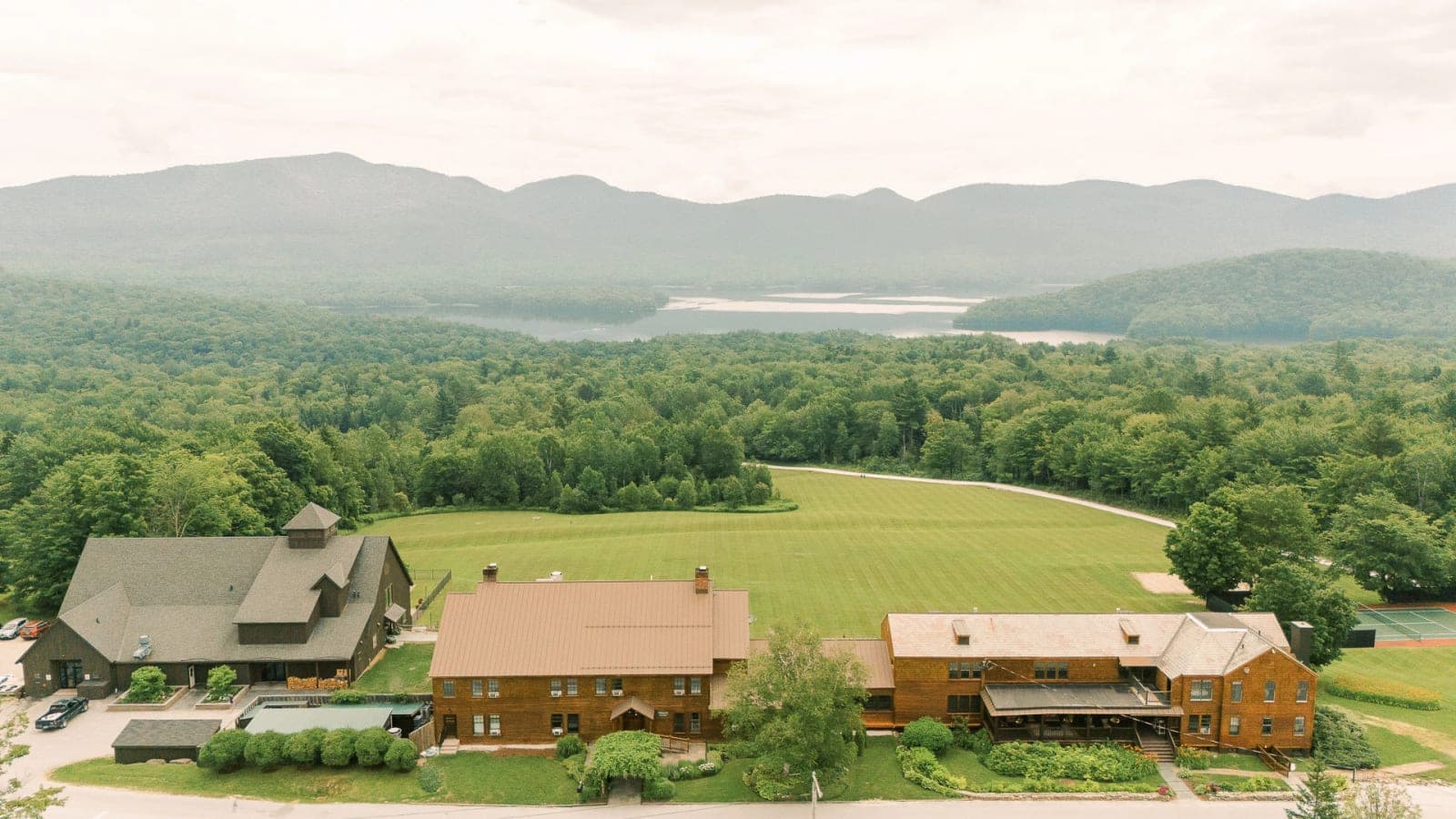 Aerial view of Mountain Top Resort's buildings with the lake and mountains beyond.