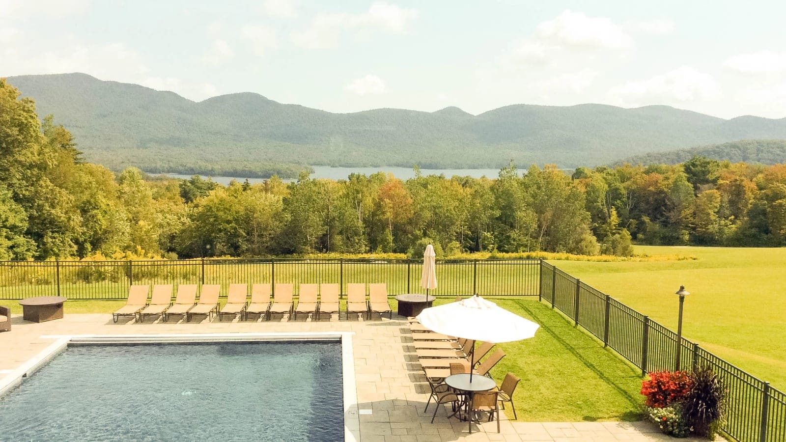 The resort pool and lounge chairs overlooking the mountains and lake.